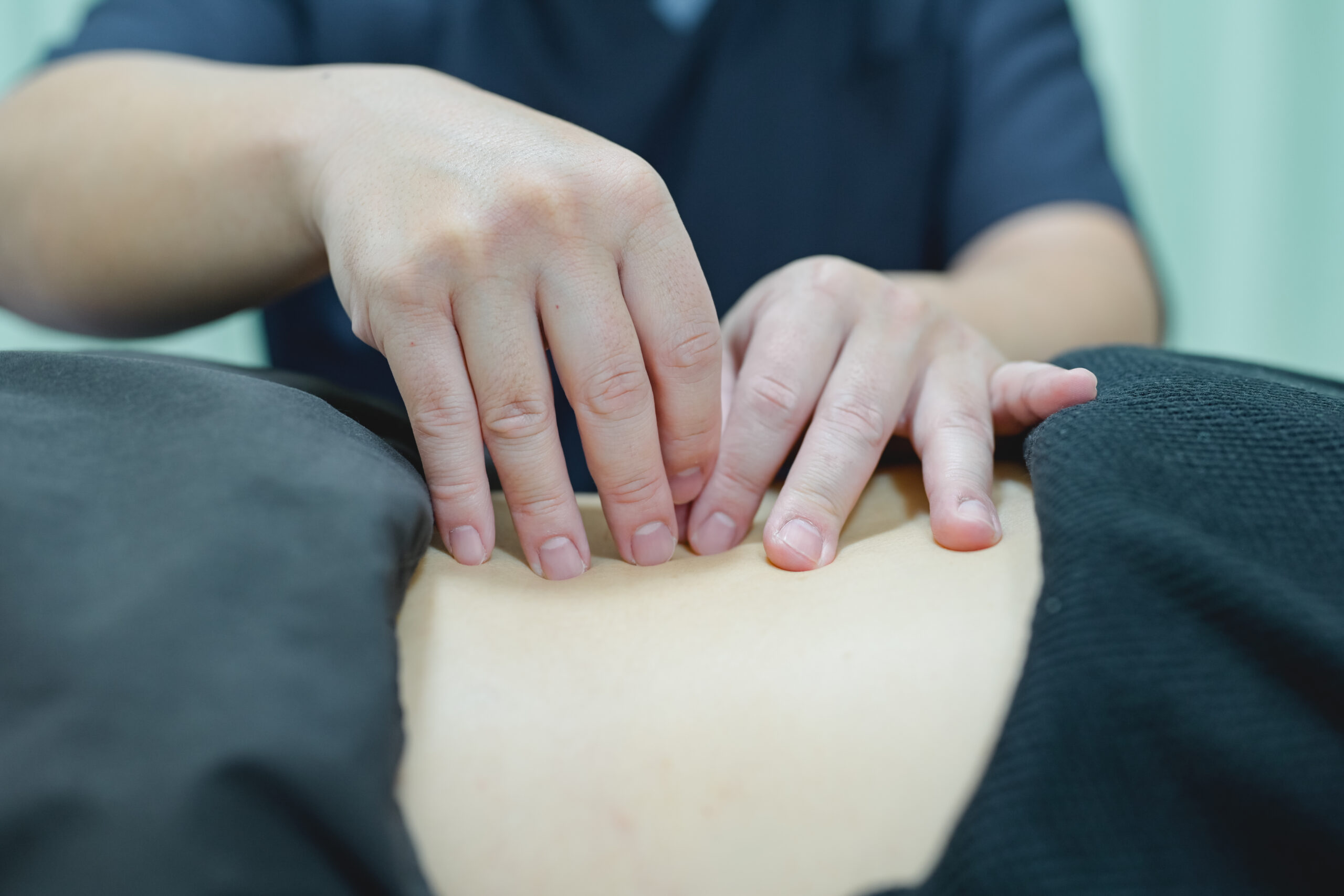 すまいる鍼灸整骨院で施術者が背中に手を当てている様子